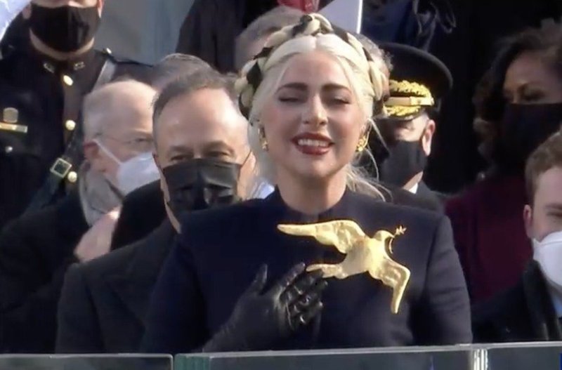 screenshot of Lady Gaga performing at the Inauguration in a navy coat and golden dove pin