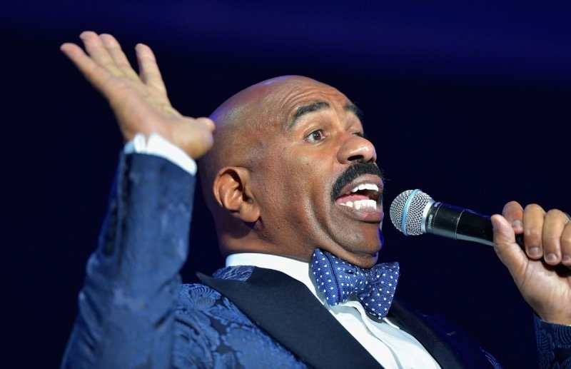 Steve Harvey wearing a blue tux onstage at the 2015 Ford Neighborhood Awards