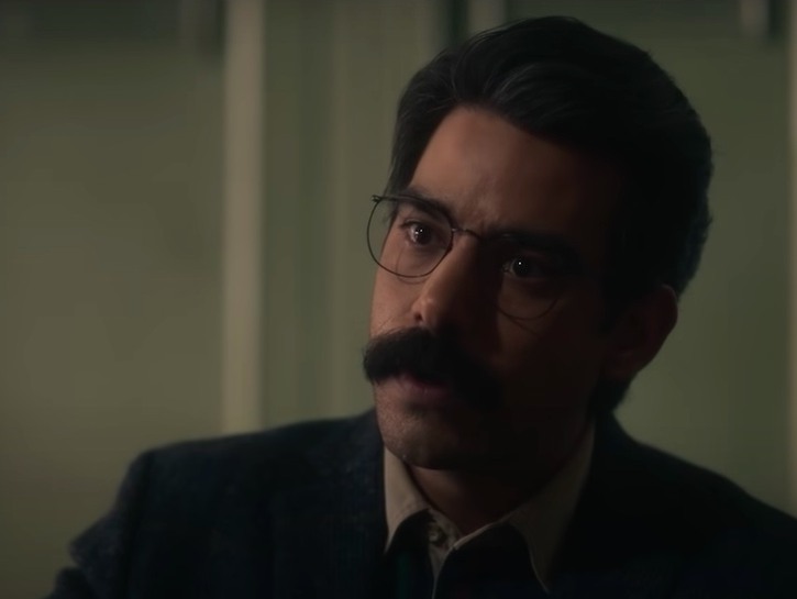 still of Rahul Kohli looking forward with a mustache in a suit as Owen in Haunting of Bly Manor