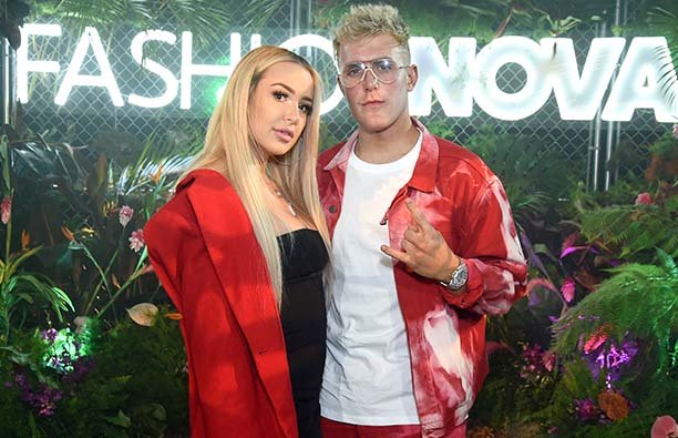 Tana Mongeau in a red jacket and black dress, Jake Paul in a red jacket and white shirt