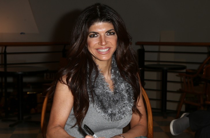 Teresa Guidice signing a copy of her book _Turning the Tables: From Housewife to Inmate and Back Again_