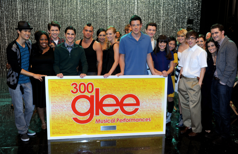 The cast of Glee standing together to celebrate their milestone of 300 musical performances