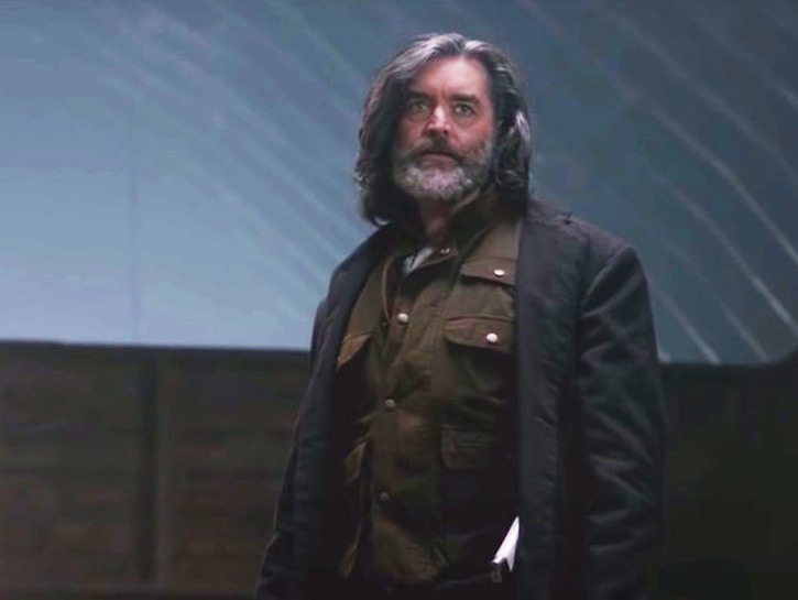 Timothy Omundson in a brown jacket and shirt portraying Cain in Supernatural