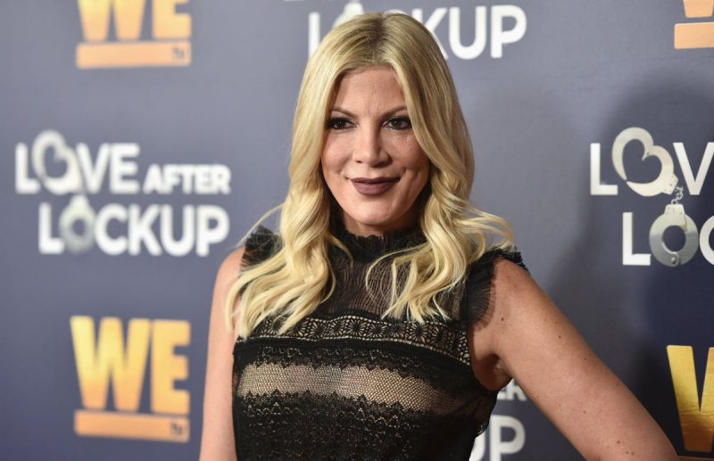 Tori Spelling wearing a black dress on the red carpet