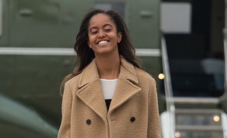 Malia Obama smiles in a tan coat