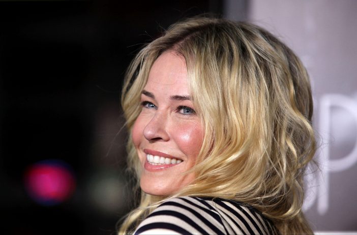 Chelsea Handler, wearing a stripped top, looks over her shoulder and smiles at the camera
