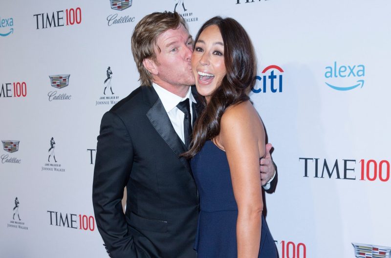 Chip Gaines plants a kiss on Joanna Gaines' cheek as she smiles for the camera