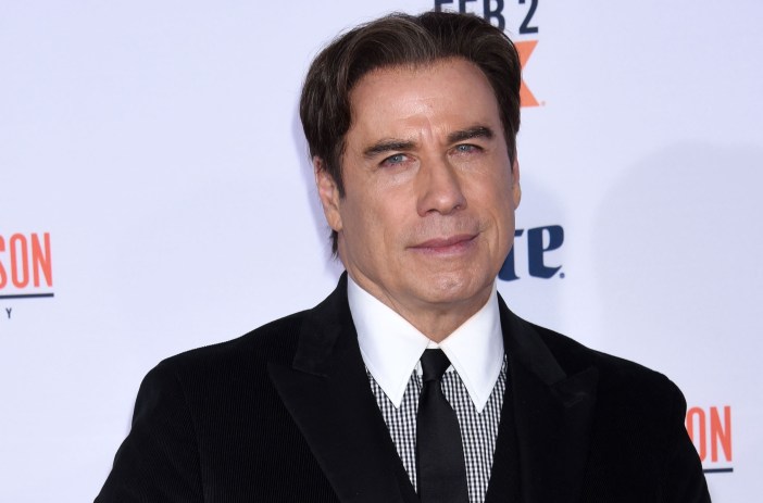 John Travolta wears a black suit while attending a movie premier.