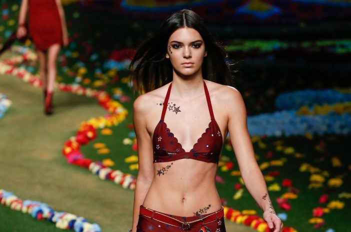 Kendall Jenner wears a red bra with red boy shorts as she walks down the catwalk