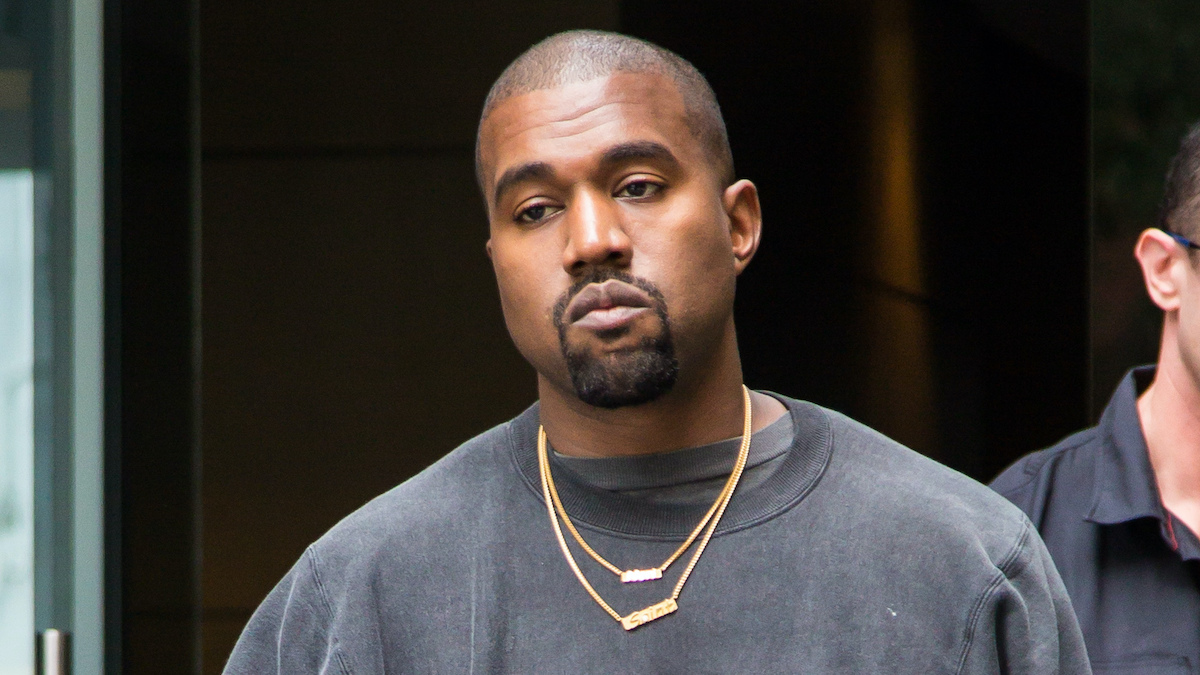 Kanye West frowning in a black sweatshirt and gold chain