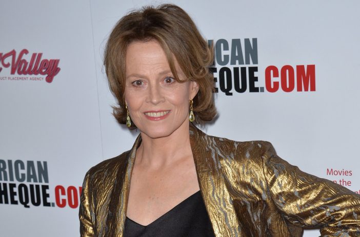 Sigourney Weaver wears a gold jacket over a black shirt on her way to a gala