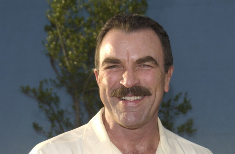 Tom Selleck wearing a light yellow button-down t-shirt in 2003