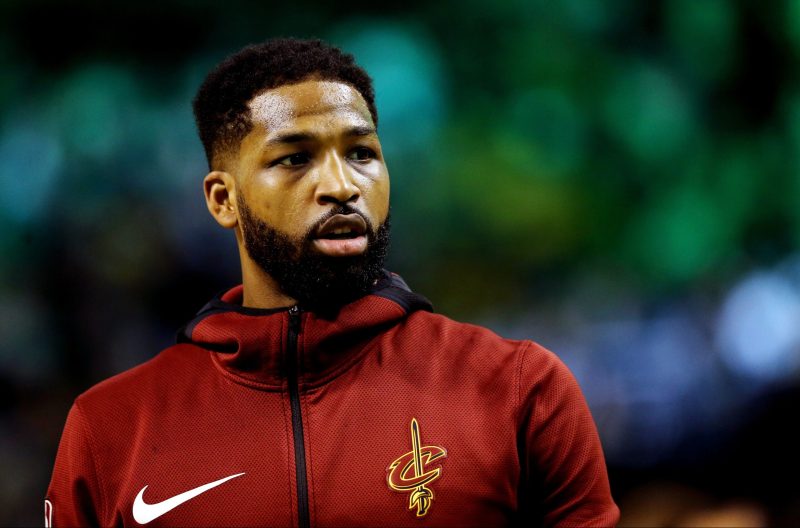 Tristan Thompson wears his red warm up sweat suit as he plays on a basketball court
