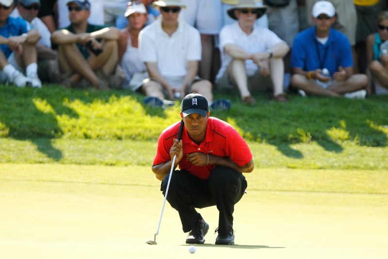 Tiger Woods crouching on a golf course