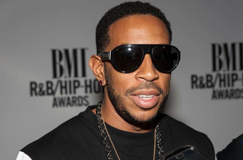 Ludacris wearing a black shirt, black sunglasses, and a black necklace.
