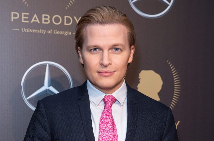 Ronan Farrow wearing a suit with pink tie at the Peabody Awards in 2019