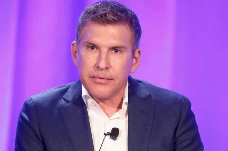 Todd Chrisley wearing a suit with his arms open.