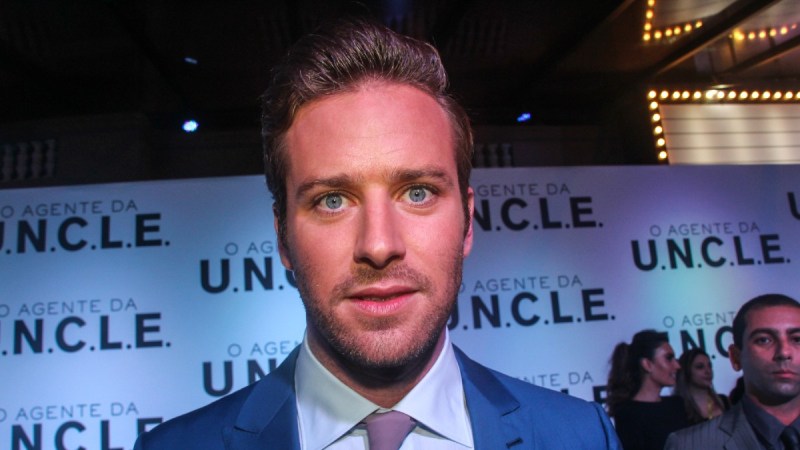 Armie Hammer wears a blue suit while walking the red carpet