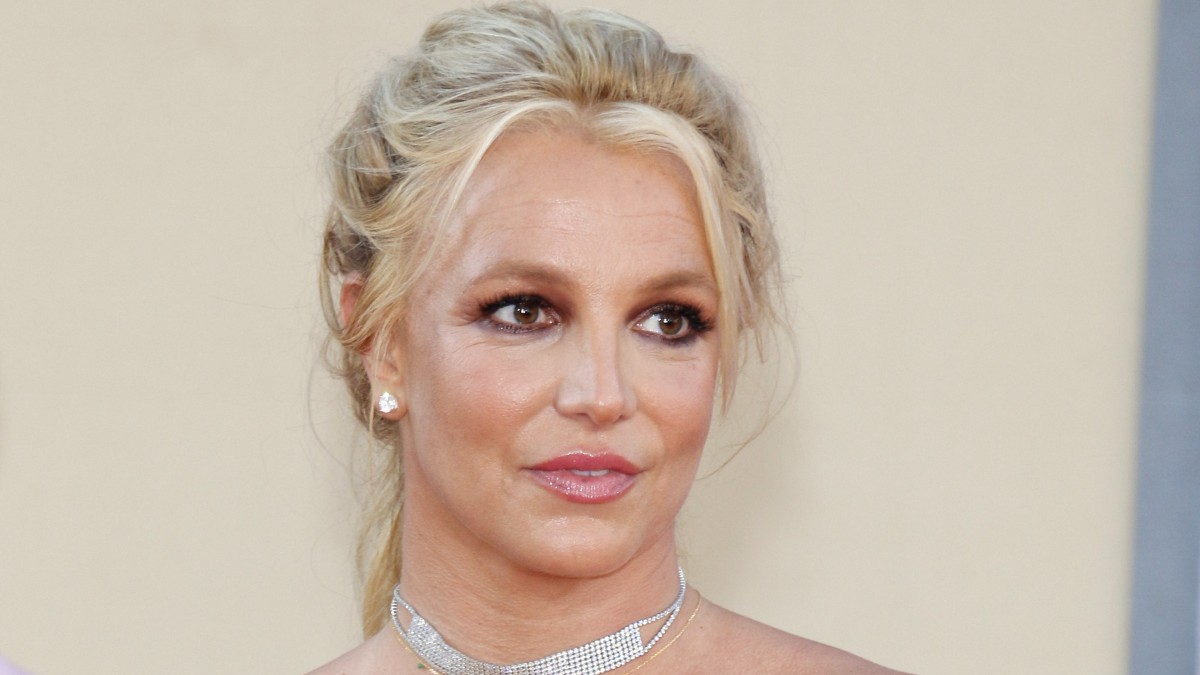 Britney Spears stands against a beige background