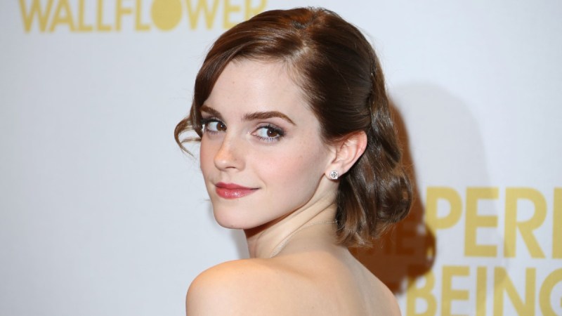 Emma Watson looks over her shoulder while wearing a strapless gown
