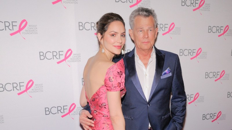 Katharine McPhee, in a pink dress, stands with David Foster, in a navy suit jacket