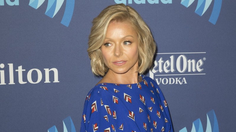 Kelly Ripa wears a blue dress with small triangles on it on the red carpet