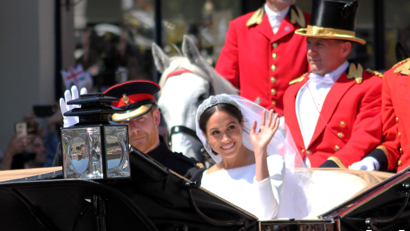 Prince Harry and Meghan Markle ride in an open carriage on the day of their wedding