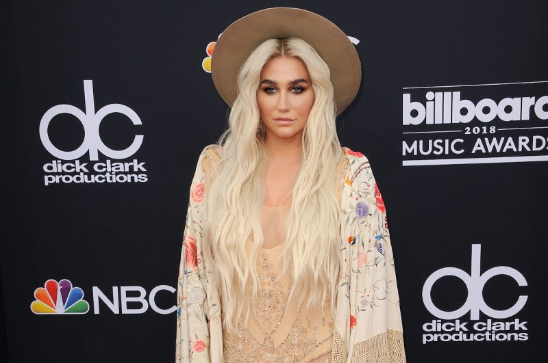 Kesha in a tan dress and hat