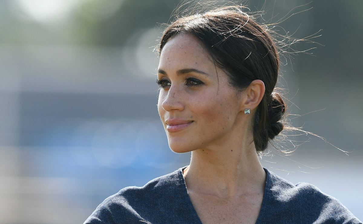 Meghan Markle smiling in a black outfit