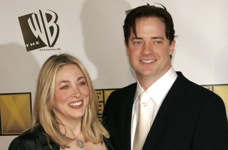 Brendan Fraser in a black suit standing next to his former wife, Afton Smith, who is wearing a black dress.