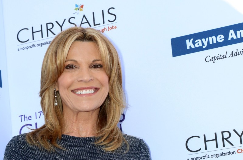 Vanna White smiling and wearing a grey dress.