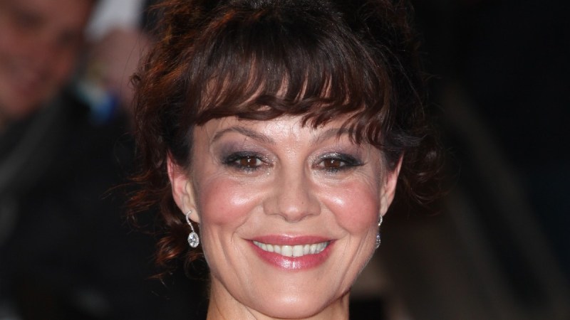 Helen McCrory, in an ivory gown, smiles as she walks the red carpet