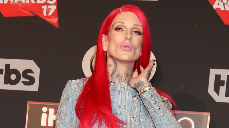 Jeffree Star wears a red wig and blue denim dress on the red carpet