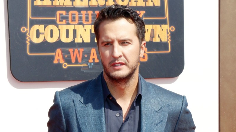 Luke Bryan wears a blue suit as he walks the red carpet at the American Country Countdown Awards