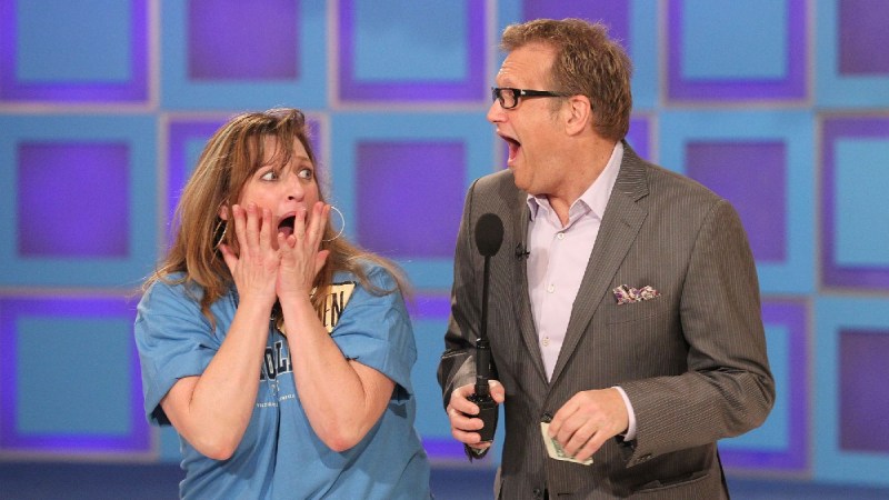 Drew Carey and a contestant on The Price Is Right make shocked faces at each other