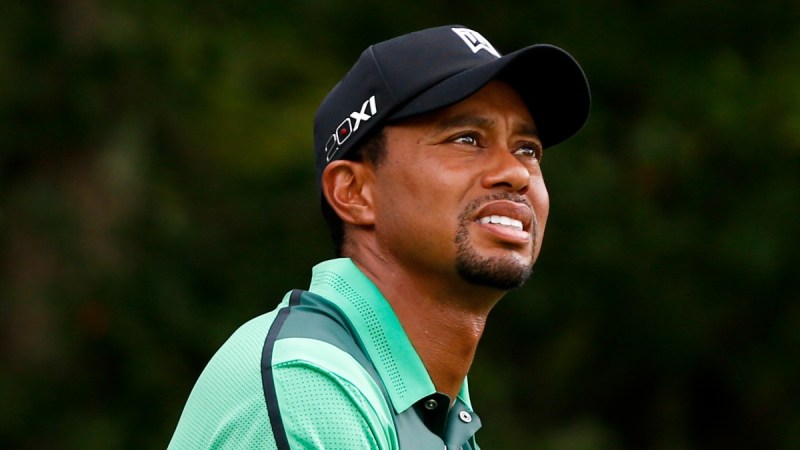 Tiger Woods wears a green shirt as he plays golf