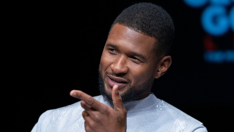 Usher addresses the audience while wearing a pale blue sweater