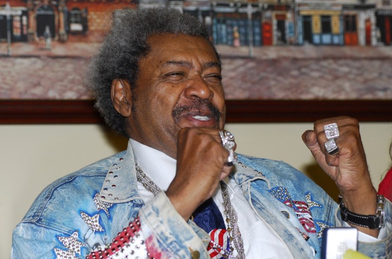 Don King wearing a glittery denim jacket and clenching his fists.
