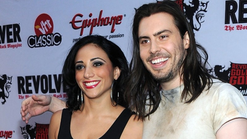 Cherie Lily, in a black leotard, stands with Andrew WK, in a grimy white t shirt, on the red carpet