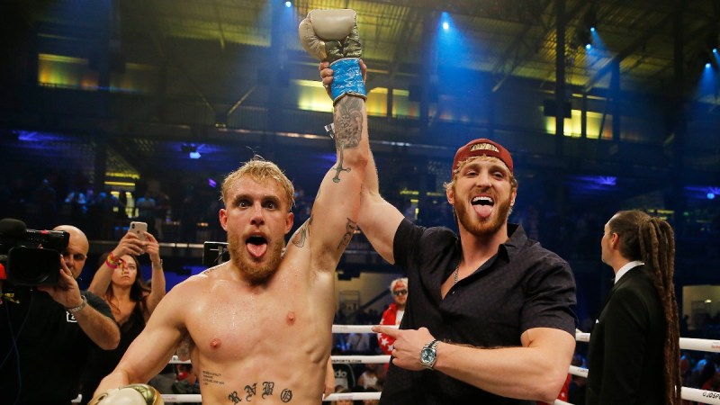 Jake and Logan Paul raise their arms and stick out their tongues after a successful fight