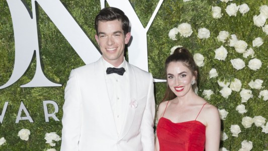 John Mulaney wears a white tux as he stands next to Annamarie Tendler on the red carpet