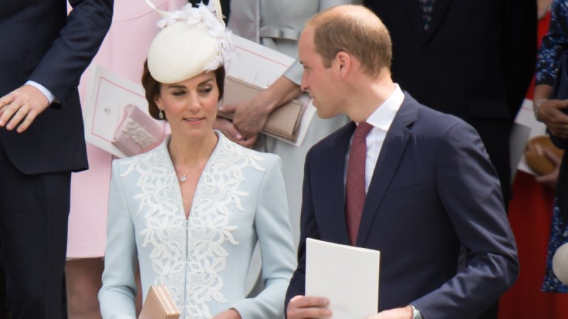 Kate Middleton, in blue, shares a look with her husband Prince William, in a dark suit