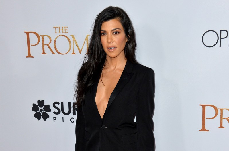 Kourtney Kardashian i a low cut black top.