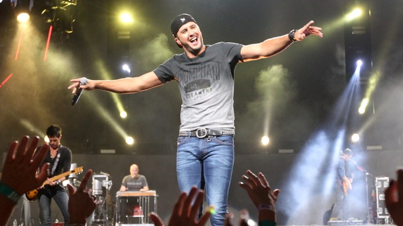 Luke Bryan wears a gray t shirt as he performs onstage