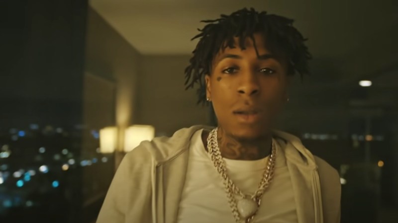 NBA YoungBoy wears a white hoodie in a music video