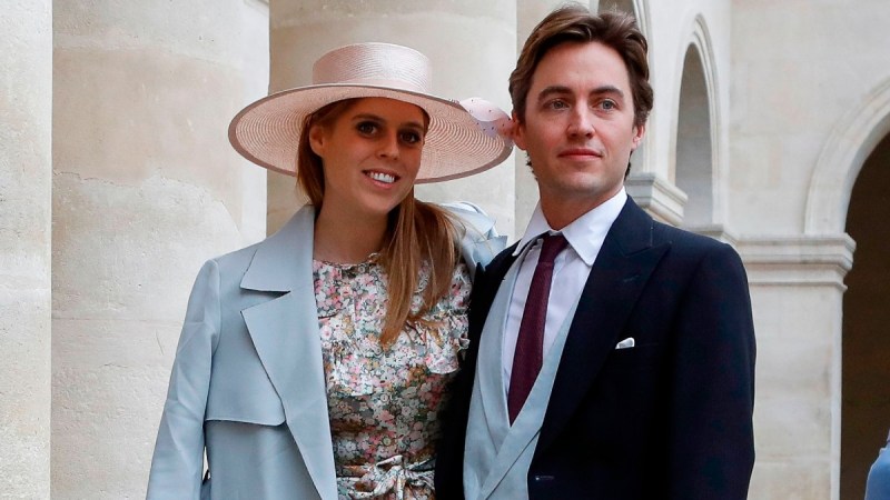 Princess Beatrice, in a floral dress and blue coat, stands with Edoardo Mapelli Mozzi at a royal event