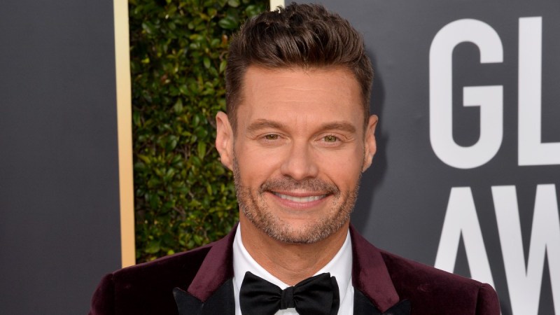 Ryan Seacrest wears a burgundy suit on the red carpet