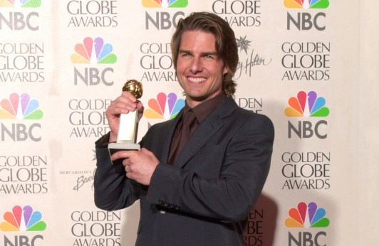 Tom Cruise holding up a Golden Globe