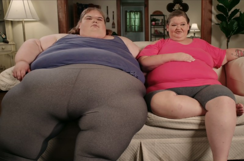 Amy and Tammy Slaton sitting on a couch wearing loungewear in an episode of '1000-Lb Sisters.'