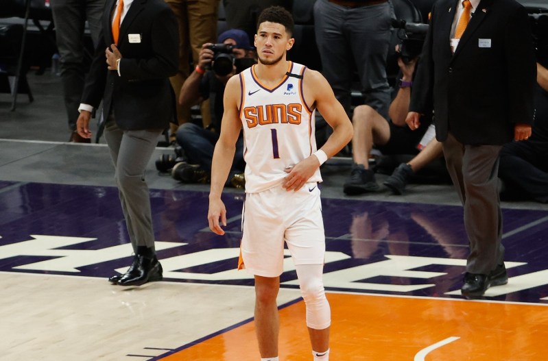 Devin Booker on the basketball court in a white jersey.